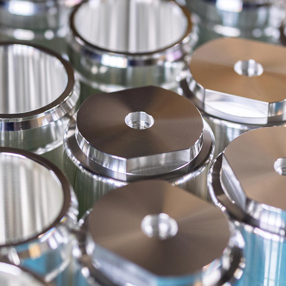 Detailaufnahme zylindrischer Metallbauteile mit mittiger Bohrung für die Oberflächenveredelung