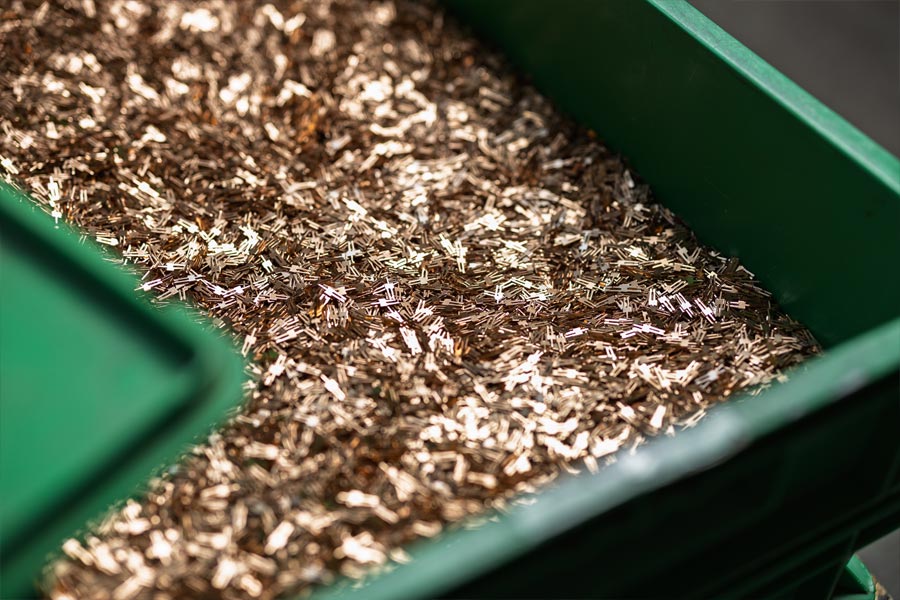 Kupferfarbene Kleinteile in einem Behälter für die Trommelgalvanik